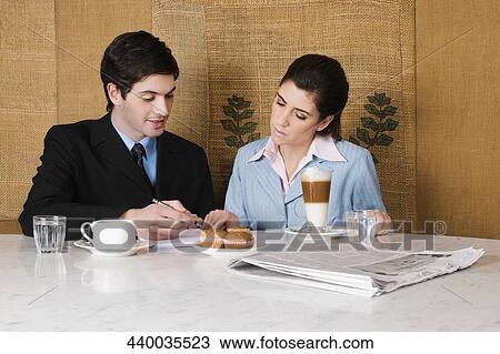Businessman and a businesswoman discussing in a cafe View Large Photo Image Stock Image - Businessman and a businesswoman discussing in a cafe. Fotosearch