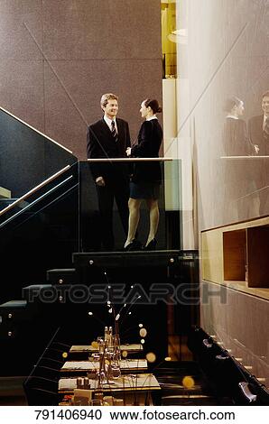 Businessman and a businesswoman standing together and smiling View Large Photo Image Stock Image - Businessman and a businesswoman standing together and smiling. Fotosearch