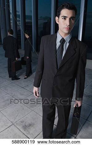 Businessman holding a briefcase View Large Photo Image Stock Photo - Businessman holding a briefcase. Fotosearch
