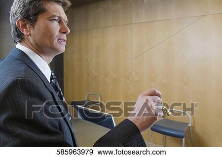 Businessman holding a service bell at hotel reception View Large Photo Image Stock Photo - Businessman holding a service bell at hotel reception. Fotosearch