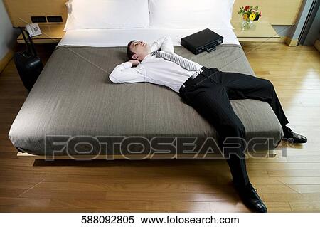 Businessman lying on the bed and thinking View Large Photo Image Stock Photography - Businessman lying on the bed and thinking. Fotosearch