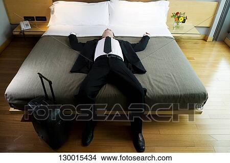 Businessman napping on the bed View Large Photo Image Picture - Businessman napping on the bed. Fotosearch