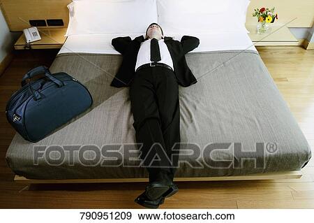 Businessman napping on the bed View Large Photo Image Stock Photo - Businessman napping on the bed. Fotosearch