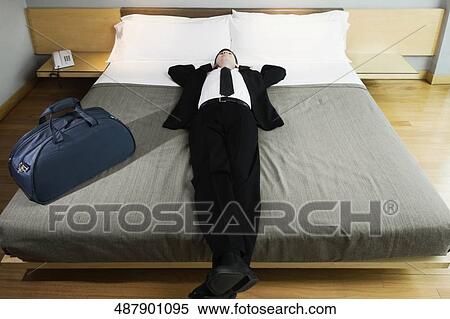 Businessman napping on the bed View Large Photo Image Stock Photography - Businessman napping on the bed. Fotosearch