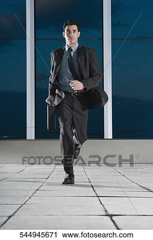 Stock Image - Businessman running in the corridor of an office. Fotosearch