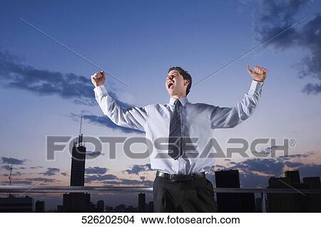 Picture - Businessman shouting with his arms outstretched. Fotosearch