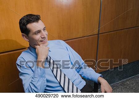 Businessman sitting in an office chair and day dreaming View Large Photo Image Stock Image - Businessman sitting in an office chair and day dreaming. Fotosearch