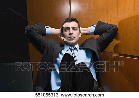 Businessman sitting in an office with his hands behind his head View Large Photo Image Stock Image - Businessman sitting in an office with his hands behind his head. Fotosearch