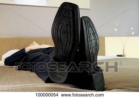 Businessman sleeping on the bed View Large Photo Image Picture - Businessman sleeping on the bed. Fotosearch
