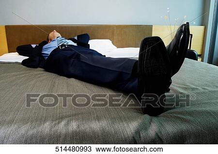 Businessman sleeping on the bed View Large Photo Image Stock Image - Businessman sleeping on the bed. Fotosearch