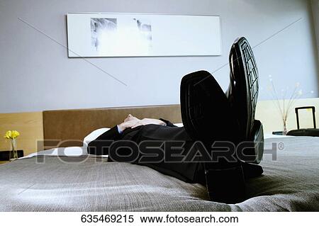 Businessman sleeping on the bed View Large Photo Image Stock Photography - Businessman sleeping on the bed. Fotosearch