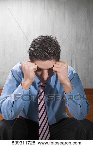 Stock Photo - Businessman suffering from a headache. Fotosearch