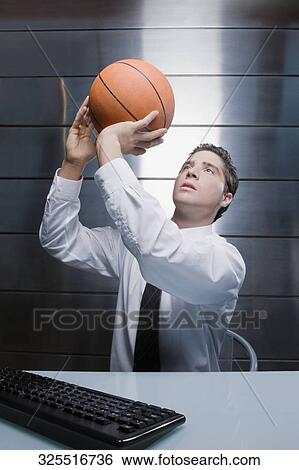 Businessman throwing a basketball View Large Photo Image Stock Photograph - Businessman throwing a basketball. Fotosearch
