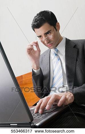 Stock Photo - Businessman using a laptop on a bench. Fotosearch