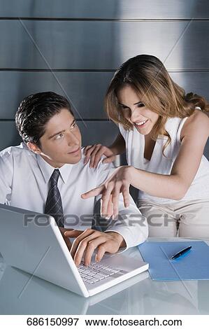 Businesswoman and a businessman planning in front of a laptop View Large Photo Image Stock Photo - Businesswoman and a businessman planning in front of a laptop. Fotosearch