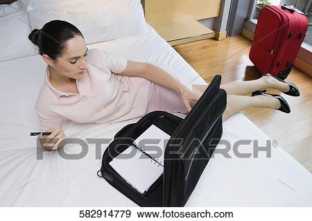 Businesswoman leaning on the bed and thinking View Large Photo Image Stock Photo - Businesswoman leaning on the bed and thinking. Fotosearch