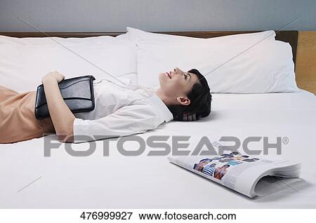 Businesswoman lying on the bed and smiling View Large Photo Image Stock Photo - Businesswoman lying on the bed and smiling. Fotosearch