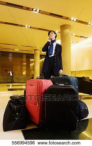Businesswoman standing in the waiting room and talking on a mobile phone View Large Photo Image Stock Photograph - Businesswoman standing in the waiting room and talking on a mobile phone. Fotosearch