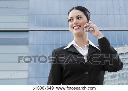 Stock Photo - Businesswoman talking on a mobile phone and smiling. Fotosearch