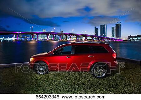 Car at the seaside with city in the background View Large Photo Image Stock Photograph - Car at the seaside with city in the background. Fotosearch