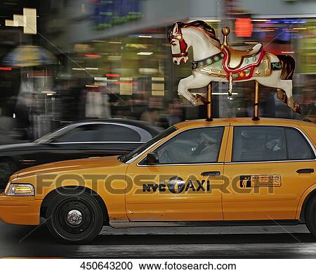 Stock Image - Carousel horse on a yellow taxi, New York City, New York State, USA. Fotosearch