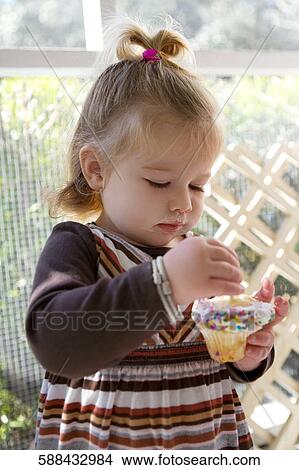 Close-up of a baby girl eating a cupcake View Large Photo Image Picture - Close-up of a baby girl eating a cupcake. Fotosearch