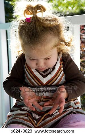 Close-up of a baby girl holding an insect View Large Photo Image Stock Image - Close-up of a baby girl holding an insect. Fotosearch