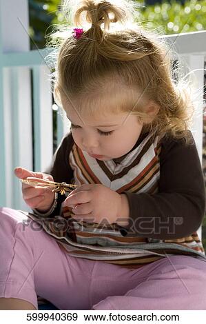Close-up of a baby girl holding an insect View Large Photo Image Stock Photo - Close-up of a baby girl holding an insect. Fotosearch