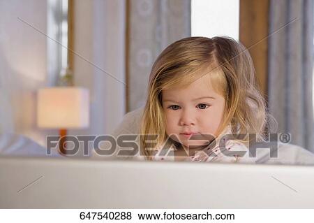 Close-up of a baby girl looking at a laptop View Large Photo Image Stock Photo - Close-up of a baby girl looking at a laptop. Fotosearch