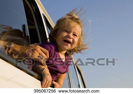 Close-up of a baby girl looking out of a car window and smiling View Large Photo Image Stock Photograph - Close-up of a baby girl looking out of a car window and smiling. Fotosearch