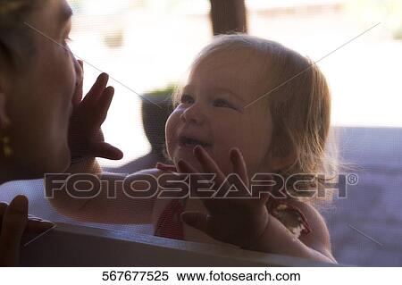 Close-up of a baby girl playing with her mother View Large Photo Image Stock Photography - Close-up of a baby girl playing with her mother. Fotosearch