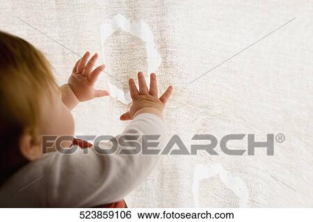 Close-up of a baby girl reaching for a curtain View Large Photo Image Stock Photograph - Close-up of a baby girl reaching for a curtain. Fotosearch