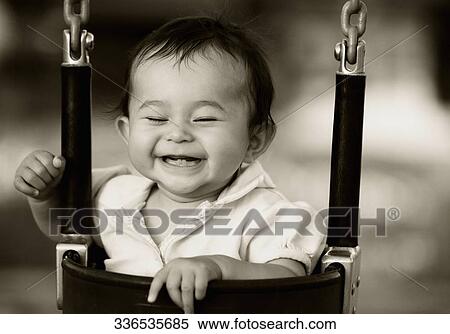 Stock Photography - Close-up of a baby girl sitting in a swing and smiling. Fotosearch