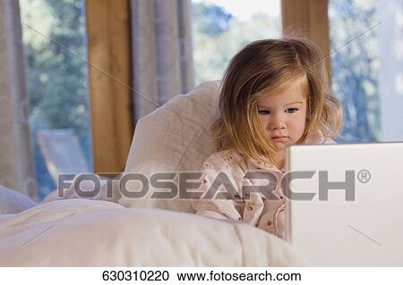Close-up of a baby girl sitting on the bed View Large Photo Image Stock Image - Close-up of a baby girl sitting on the bed. Fotosearch