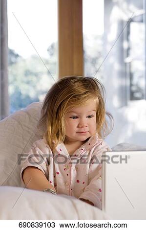 Close-up of a baby girl sitting on the bed View Large Photo Image Stock Image - Close-up of a baby girl sitting on the bed. Fotosearch