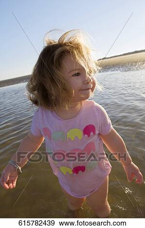 Close-up of a baby girl standing in water and looking away View Large Photo Image Stock Photo - Close-up of a baby girl standing in water and looking away. Fotosearch