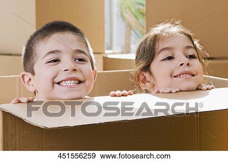 Close-up of a boy and a girl smiling in a cardboard box View Large Photo Image Stock Photo - Close-up of a boy and a girl smiling in a cardboard box. Fotosearch