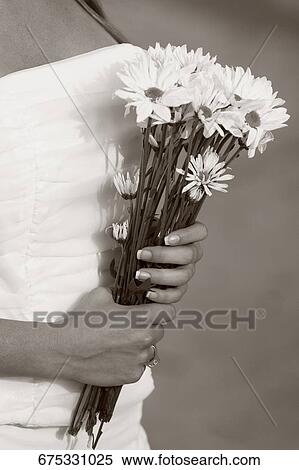 Close-up of a bride holding a bunch of flowers View Large Photo Image Stock Photography - Close-up of a bride holding a bunch of flowers. Fotosearch