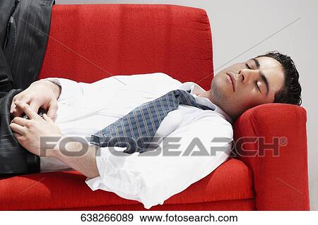 Stock Photo - Close-up of a businessman sleeping on a couch. Fotosearch