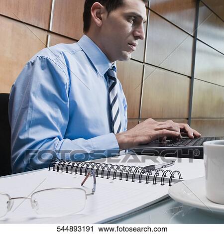 Stock Image - Close-up of a businessman working on a laptop. Fotosearch