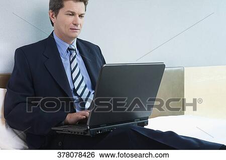 Close-up of a businessman working on a laptop View Large Photo Image Stock Photograph - Close-up of a businessman working on a laptop. Fotosearch