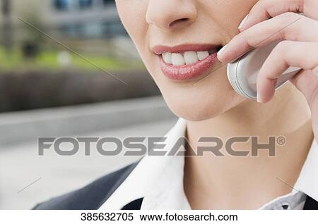Close-up of a businesswoman talking on a mobile phone and smiling View Large Photo Image Stock Photography - Close-up of a businesswoman talking on a mobile phone and smiling. Fotosearch