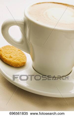 Close-up of a coffee cup with a biscuit in a saucer View Large Photo Image Stock Photography - Close-up of a coffee cup with a biscuit in a saucer. Fotosearch