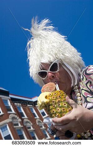 Close-up of a gay man drinking juice from a pineapple View Large Photo Image Stock Photo - Close-up of a gay man drinking juice from a pineapple. Fotosearch