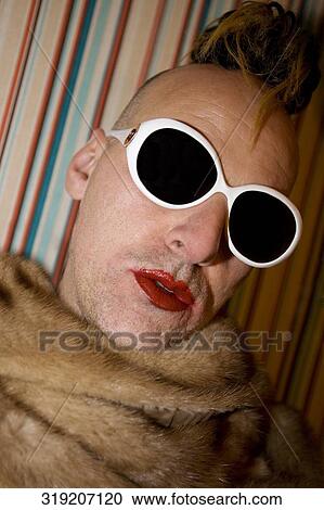 Stock Image - Close-up of a gay man wearing sunglasses. Fotosearch