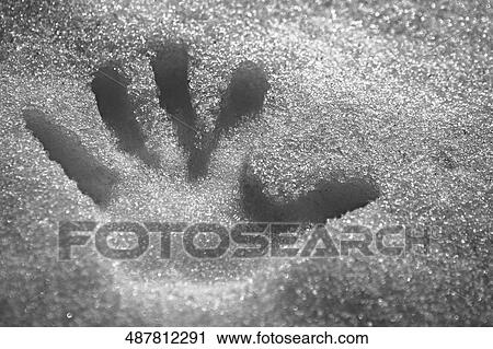 Stock Image - Close-up of a handprint in snow. Fotosearch