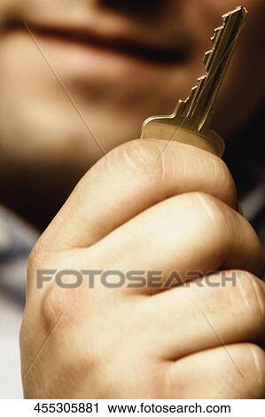 Close-up of a man holding a key View Large Photo Image Stock Image - Close-up of a man holding a key. Fotosearch