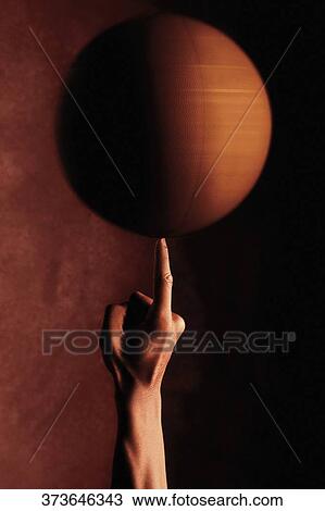 Stock Image - Close-up of a man spinning a basketball on an index finger. Fotosearch