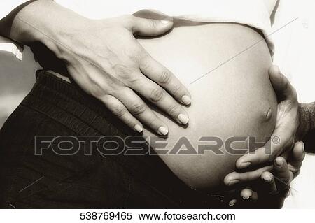 Close-up of a man's hand touching the abdomen of a pregnant woman View Large Photo Image Stock Photography - Close-up of a man's hand touching the abdomen of a pregnant woman. Fotosearch