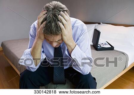 Close-up of a mature man sitting with his head in his hands View Large Photo Image Stock Photo - Close-up of a mature man sitting with his head in his hands. Fotosearch